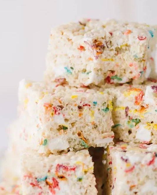 A stack of marshmallow rice treats with a combination of white and rainbow colored marshmallows